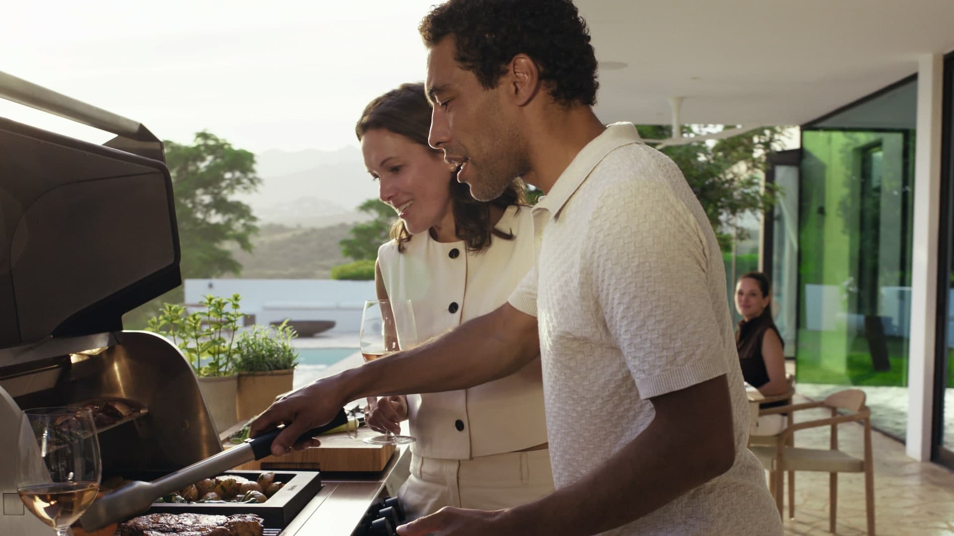 Paar grillt an der Miele Outdoor-Küche